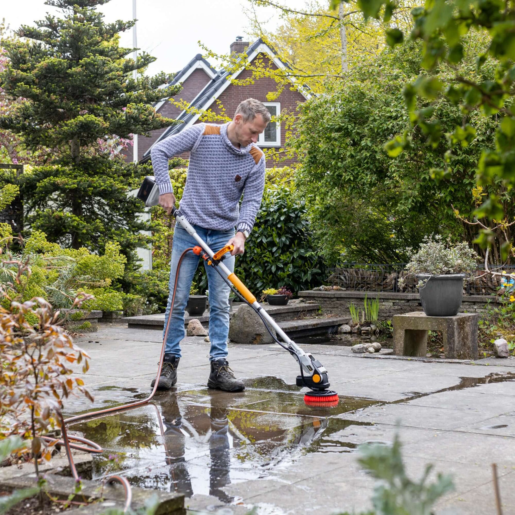 Foto zeigt die Twin Brush, die an einen Gartenschlauch angeschlossen ist, für kontinuierliches Arbeiten